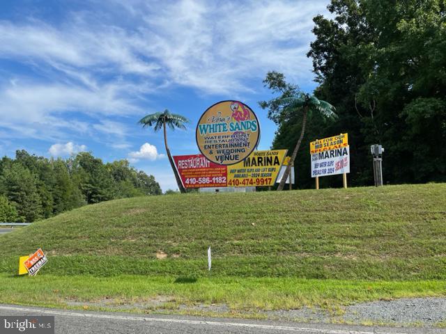 8202 Sycamore Road Lusby, MD 20657 - Photo 2 of 8 a sign board with tall trees