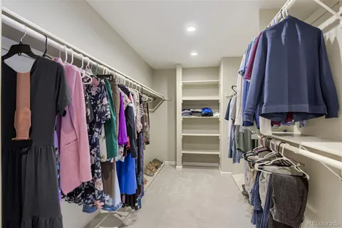 a view of walk in closet with clothes and shoes