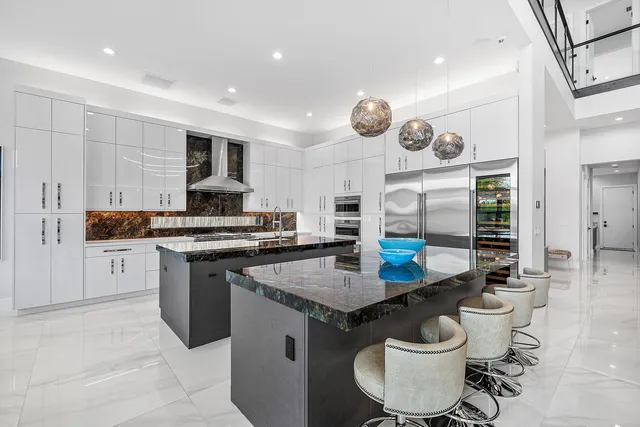 a kitchen with stainless steel appliances kitchen island granite countertop a sink and a refrigerator