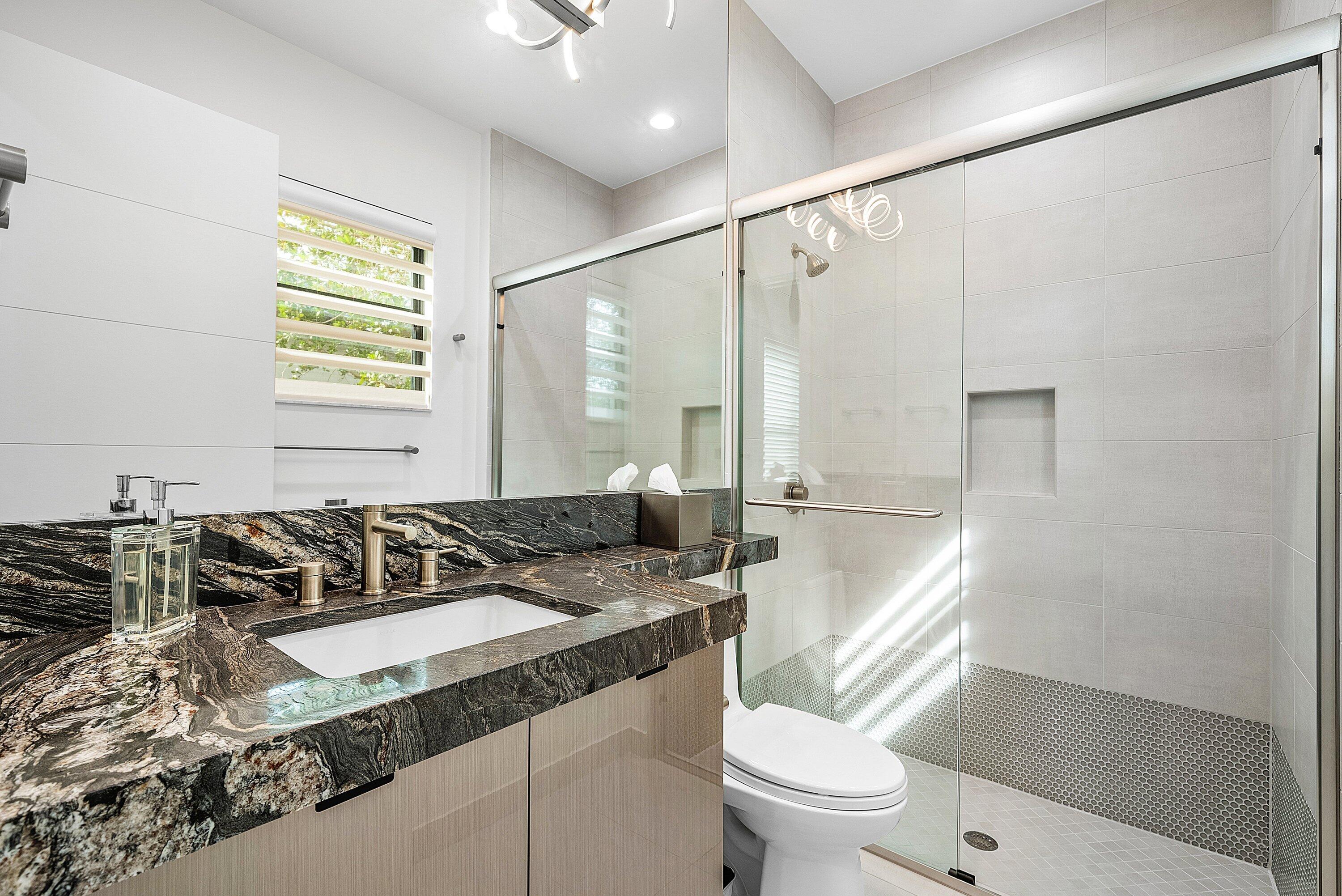 9569 Vescovato Way Boca Raton, FL 33496 - Photo 41 of 98 a bathroom with a granite countertop sink a mirror a toilet and a shower