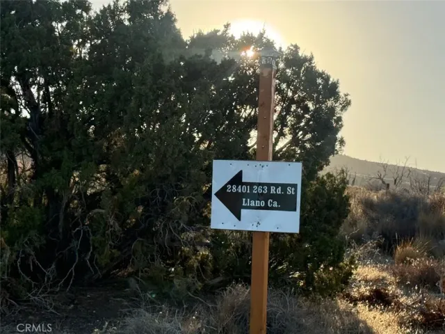 a sign board with a house in the background