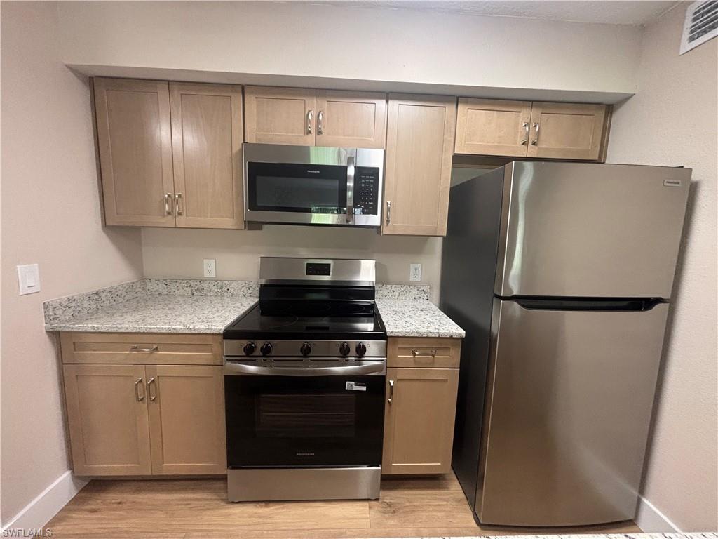 5305 Summerlin Road, Unit 501 Fort Myers, FL 33919 - Photo 4 of 10 a kitchen with a refrigerator stove and microwave