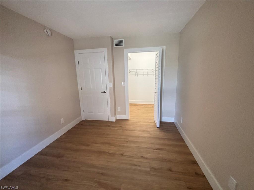 5305 Summerlin Road, Unit 501 Fort Myers, FL 33919 - Photo 8 of 10 a view of an empty room with wooden floor