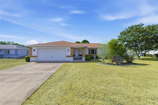 a front view of a house with a garden and yard
