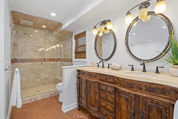 a spacious bathroom with a granite countertop sink a toilet and a mirror