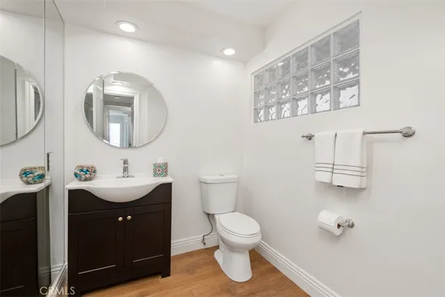 a spacious bathroom with a granite countertop sink a toilet and a mirror