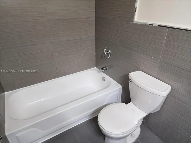 a white toilet sitting next to a bathroom sink