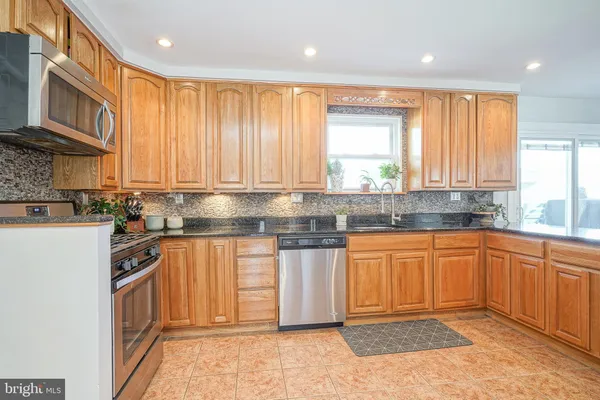 a kitchen with stainless steel appliances granite countertop wooden cabinets a sink and a stove