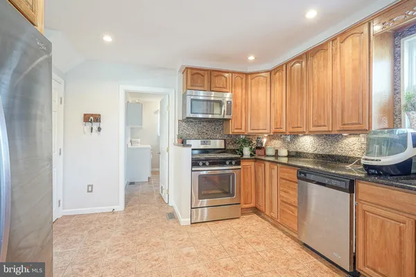 a kitchen with stainless steel appliances granite countertop a stove a sink and a refrigerator