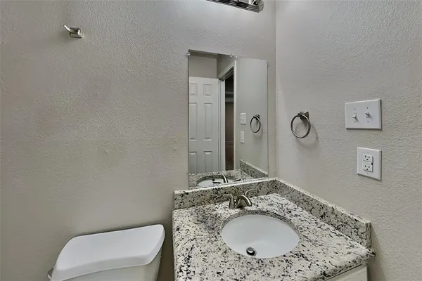 an empty room with chandelier fan and windows