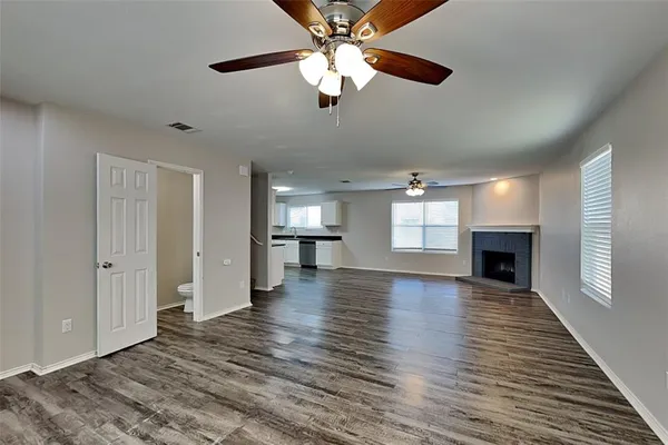 a view of empty room with wooden floor and fireplace