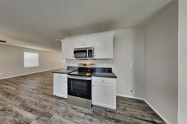 a kitchen with a sink a stove top oven and white stainless steel appliances