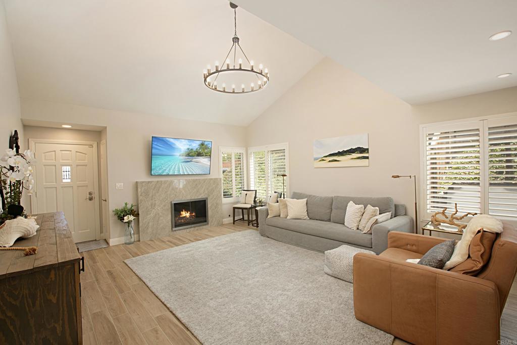 a living room with furniture a fireplace and a chandelier