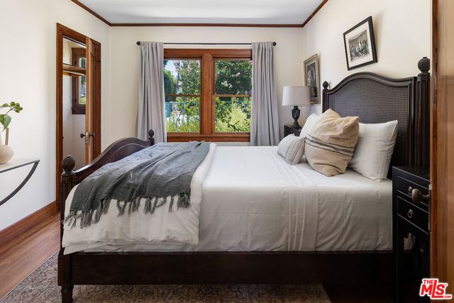 a bedroom with a bed and wooden floor