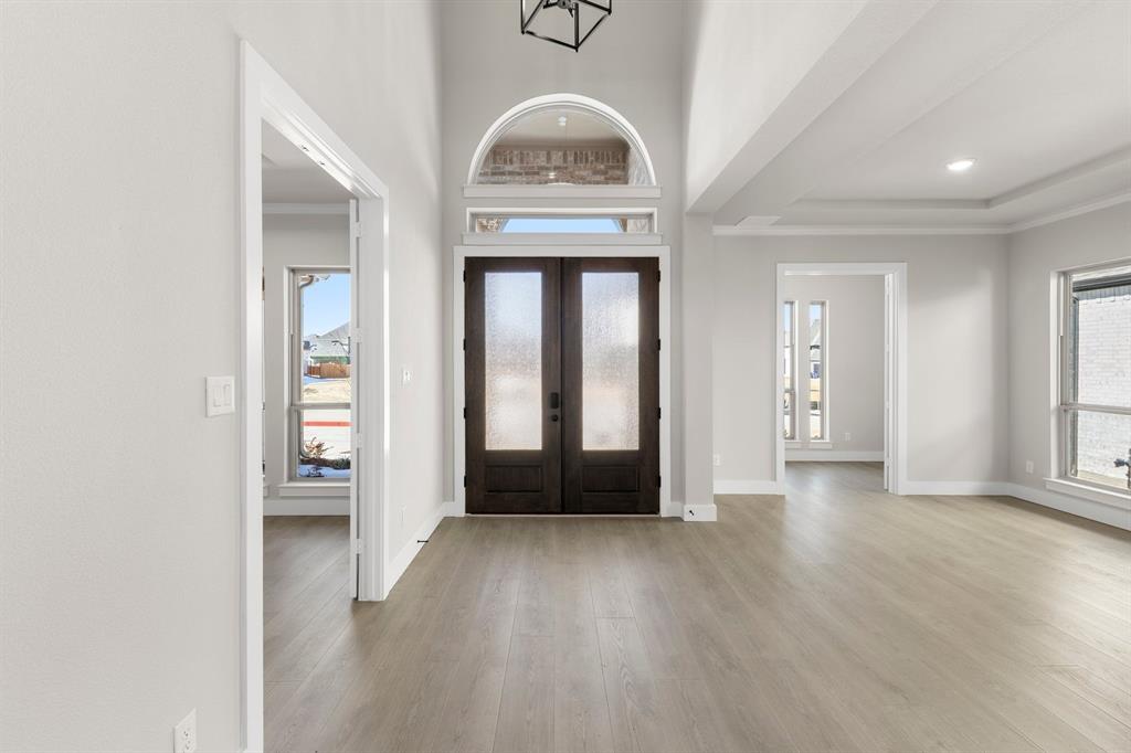 14994 Chipping Trail Frisco, TX 75035 - Photo 13 of 40 an entryway at an empty room with wooden floor and a window