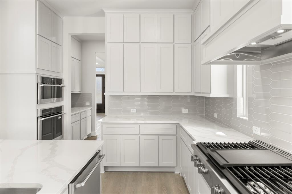 14994 Chipping Trail Frisco, TX 75035 - Photo 22 of 40 a kitchen with stainless steel appliances a refrigerator a stove and white cabinets