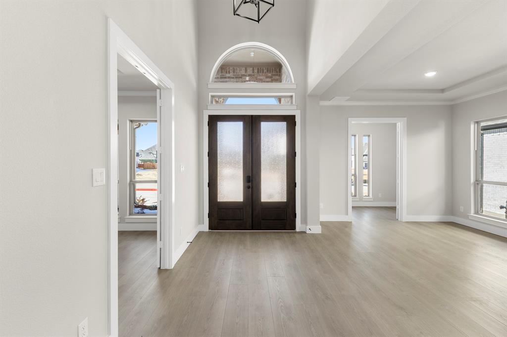 14994 Chipping Trail Frisco, TX 75035 - Photo 6 of 40 an entryway at an empty room with wooden floor and a window