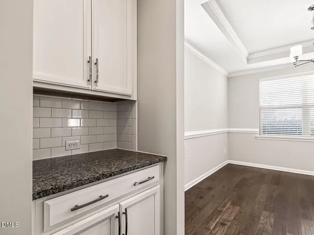 a kitchen with granite countertop white cabinets and a stove