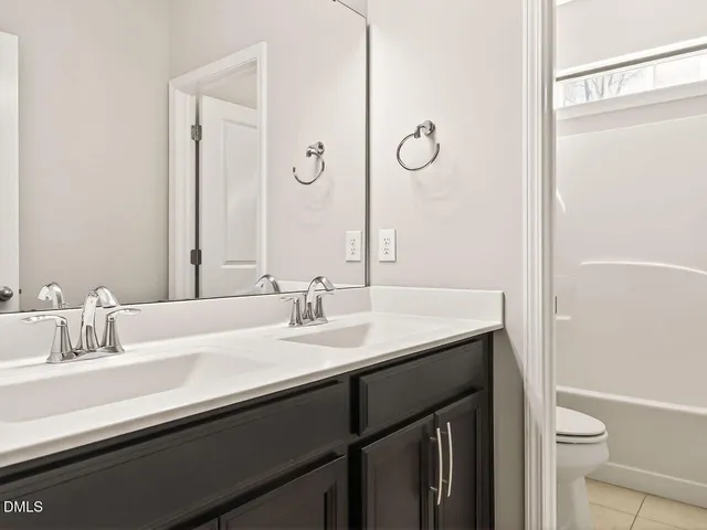 a bathroom with a granite countertop sink a toilet and a mirror