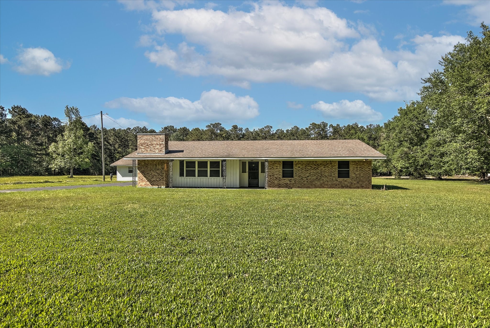 411 County Road 2298 Cleveland, TX 77327 - Photo 3 of 47 a front view of a house with a garden