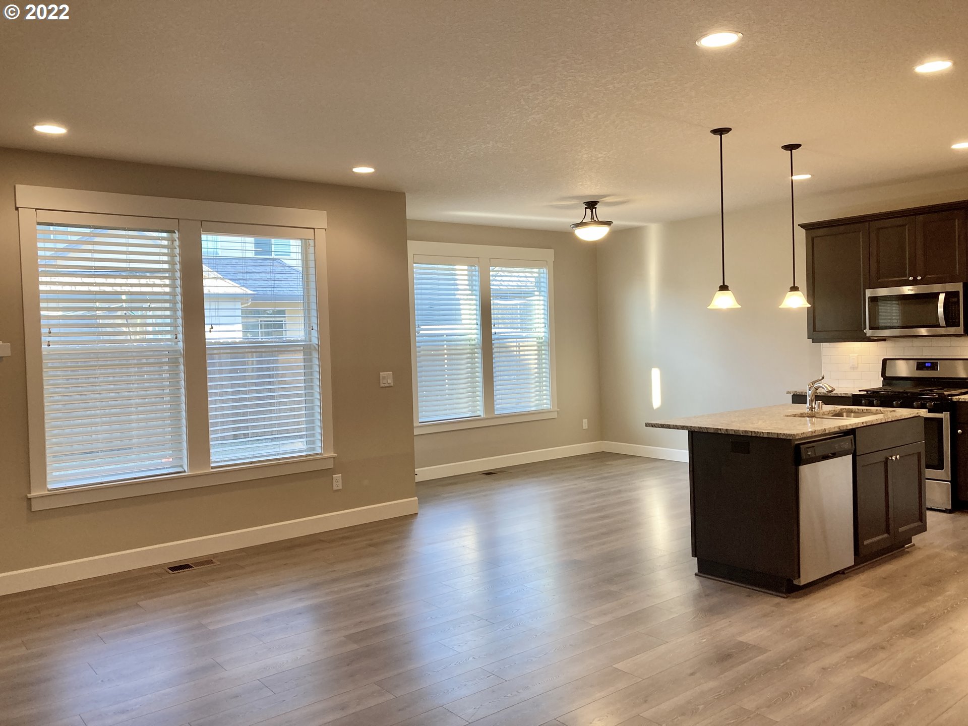 1201 South Quail Run Place Ridgefield, WA 98642 - Photo 5 of 27 a kitchen with stainless steel appliances granite countertop a sink and a wooden floor