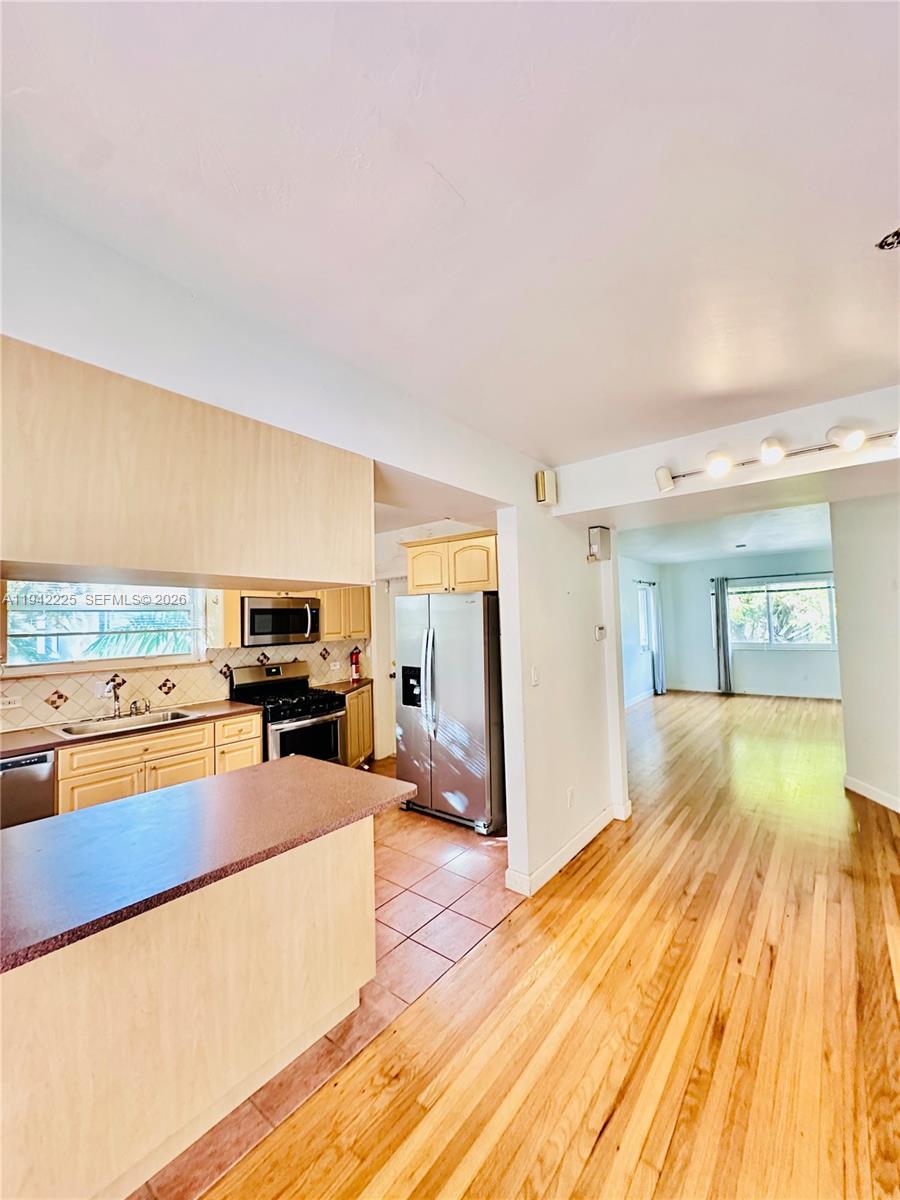 1180 Southwest 22nd Terrace, Unit 1 Miami, FL 33129 - Photo 12 of 32 a large kitchen with a large counter top a stove and a refrigerator