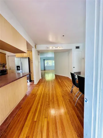 an empty room with wooden floor and window