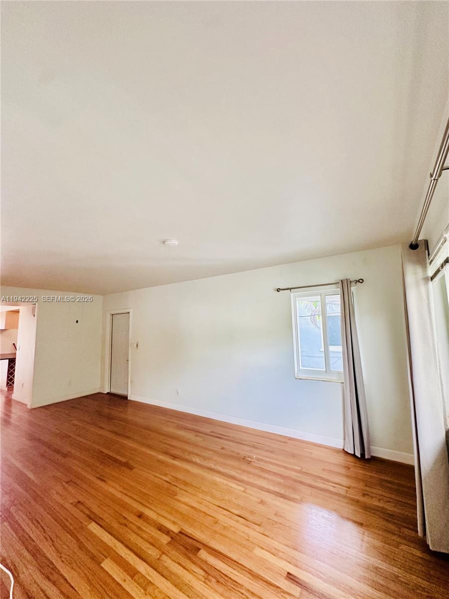 1180 Southwest 22nd Terrace, Unit 1 Miami, FL 33129 - Photo 18 of 32 an empty room with wooden floor and window