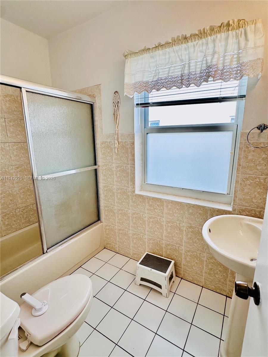 1180 Southwest 22nd Terrace, Unit 1 Miami, FL 33129 - Photo 25 of 32 a bathroom with a toilet a sink and mirror