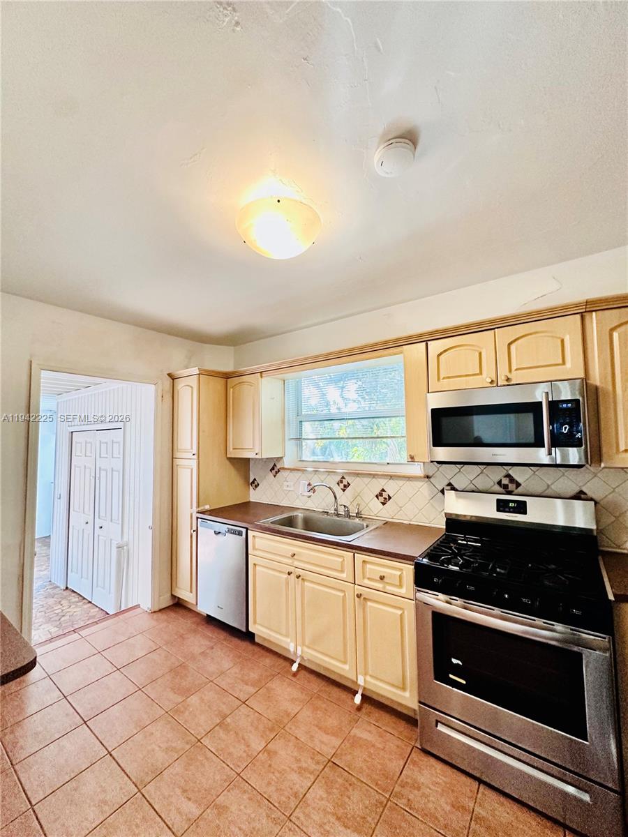 1180 Southwest 22nd Terrace, Unit 1 Miami, FL 33129 - Photo 8 of 32 a kitchen with stainless steel appliances granite countertop a stove and a sink