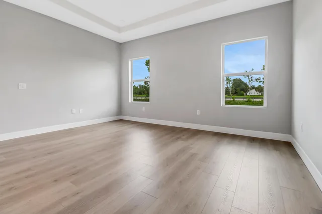 an empty room with wooden floor and window
