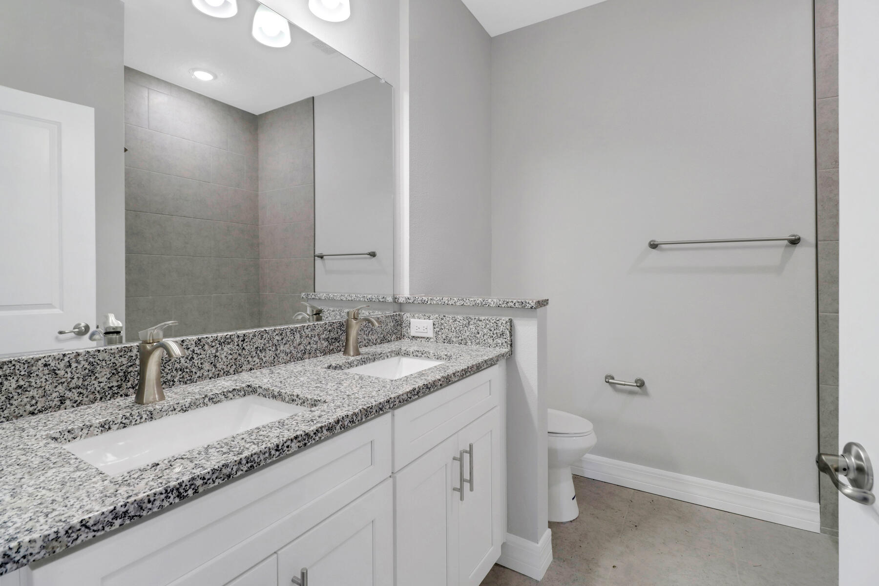 23158 Ranger Avenue Port Charlotte, FL 33954 - Photo 18 of 25 a bathroom with a granite countertop sink a toilet and a mirror