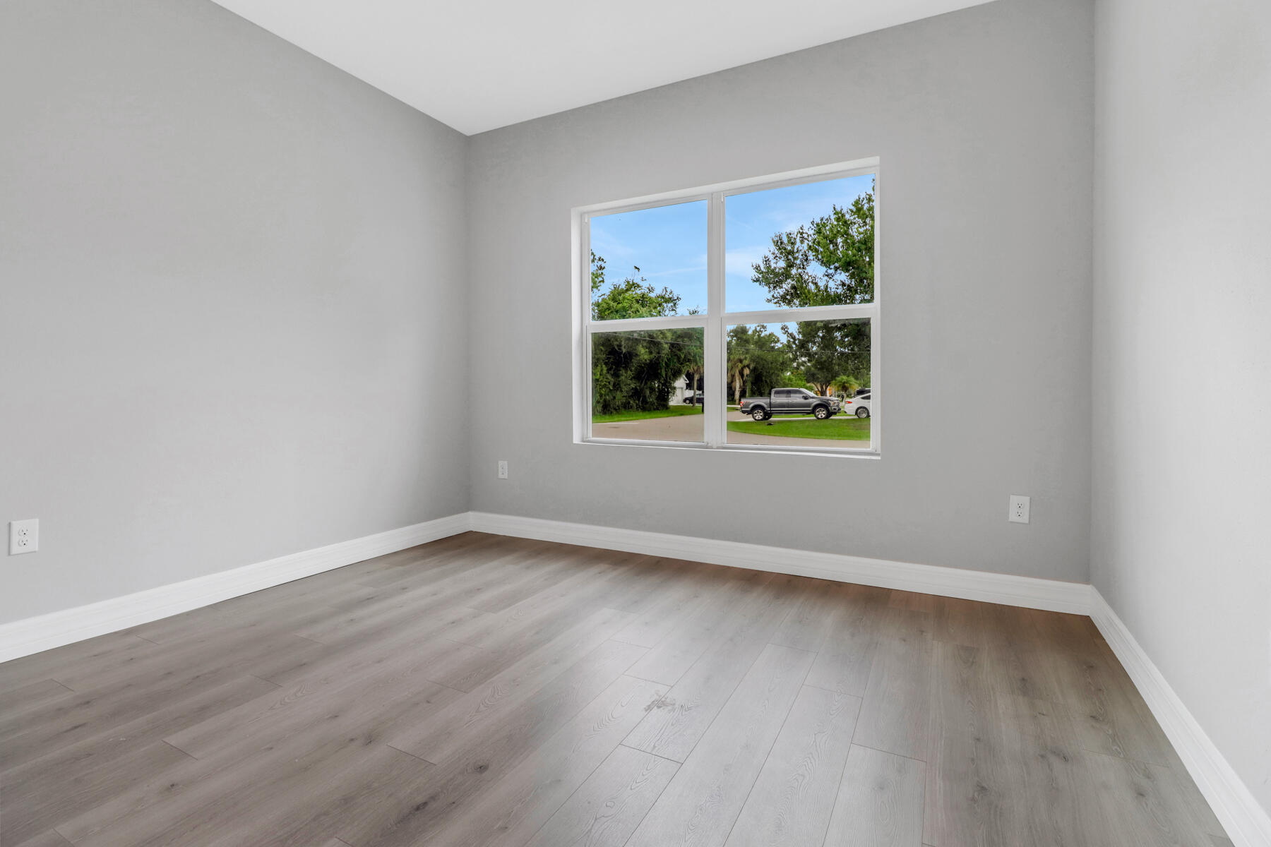 23158 Ranger Avenue Port Charlotte, FL 33954 - Photo 19 of 25 a view of an empty room with wooden floor and a window