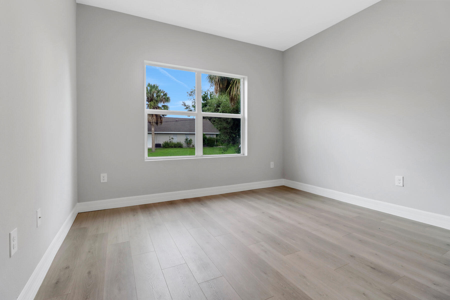 23158 Ranger Avenue Port Charlotte, FL 33954 - Photo 20 of 25 an empty room with wooden floor and windows