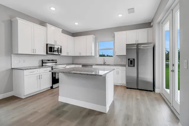 a kitchen with stainless steel appliances a refrigerator sink and microwave