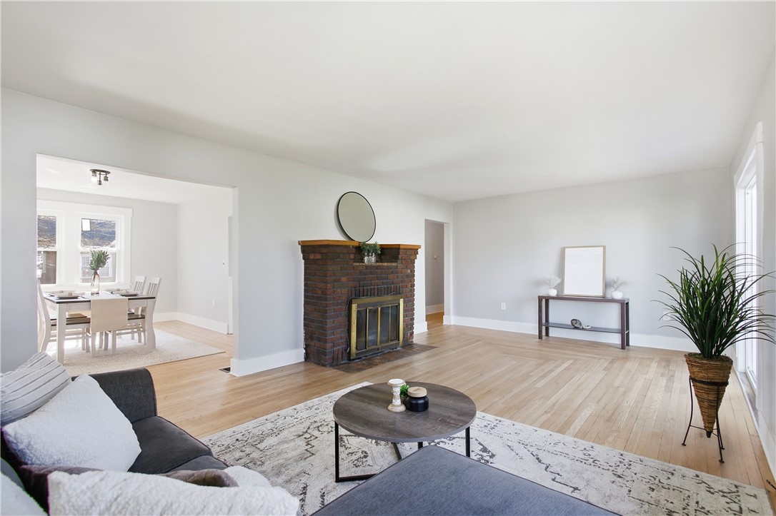 1925 Sunset Avenue Springfield, OH 45505 - Photo 12 of 45 This airy living area features beautiful hardwood floors and a brick fireplace, offering a cozy ambiance.
