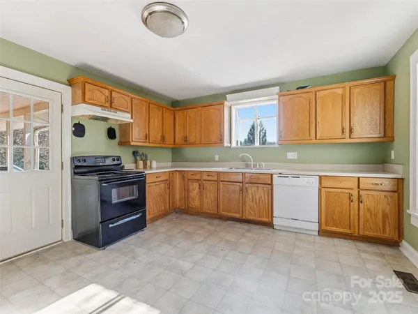 a kitchen with granite countertop a stove top oven sink and cabinets