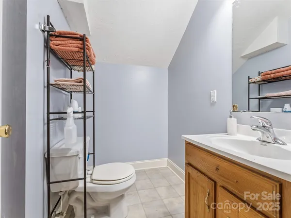 a bathroom with a toilet sink vanity and mirror
