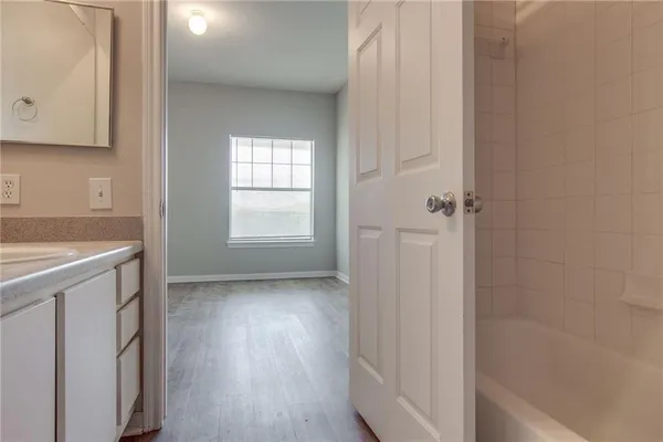 a view of an empty room with closet and a window