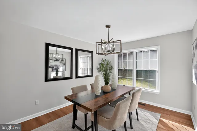 a view of a dining room with furniture a chandelier and wooden floor