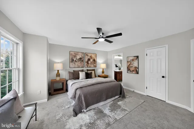 a bedroom with a large bed couch and a window
