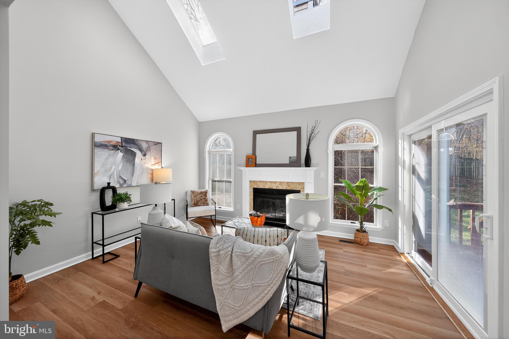 9310 Bellbeck Road Baltimore, MD 21234 - Photo 3 of 30 a living room with furniture a fireplace and a potted plant with wooden floor