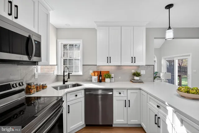 a kitchen with white cabinets stainless steel appliances and sink