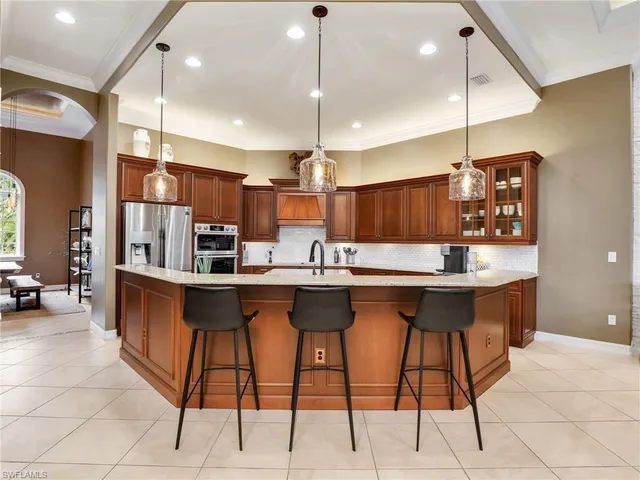 a kitchen with stainless steel appliances kitchen island a table chairs in it and wooden floors