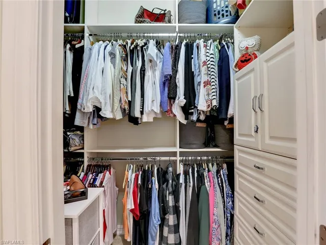 a view of walk in closet with clothes