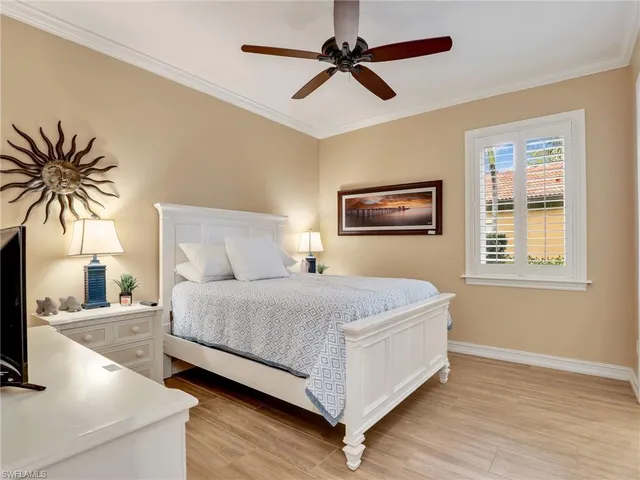 a spacious bedroom with a bed and a flat screen tv