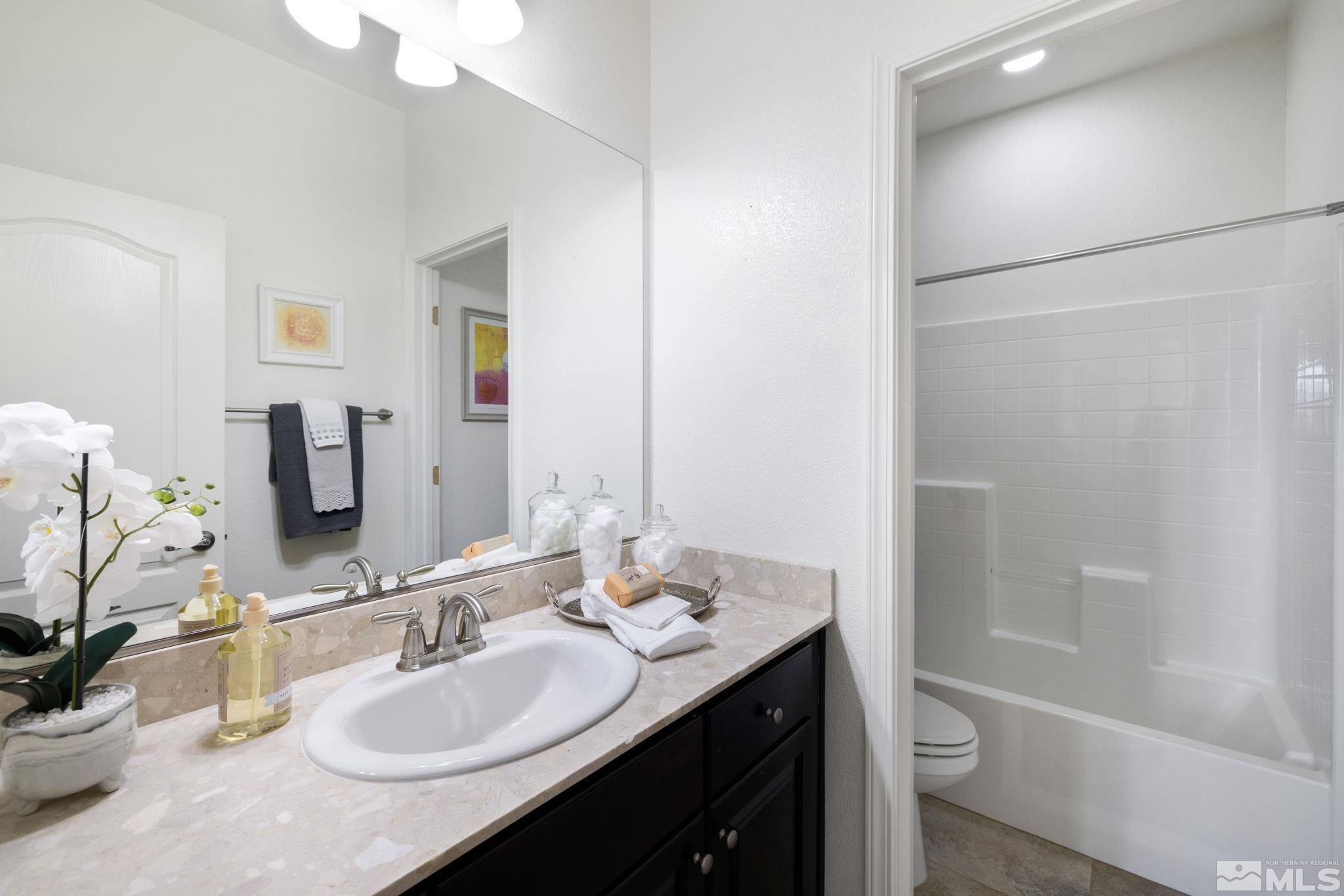 10656 Foxberry Park Drive Reno, NV 89521 - Photo 21 of 31 a bathroom with a granite countertop sink toilet and shower