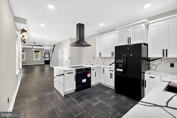 a kitchen with stainless steel appliances granite countertop a refrigerator a stove and a sink