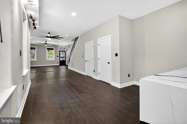 a view of a hallway with wooden floor and staircase