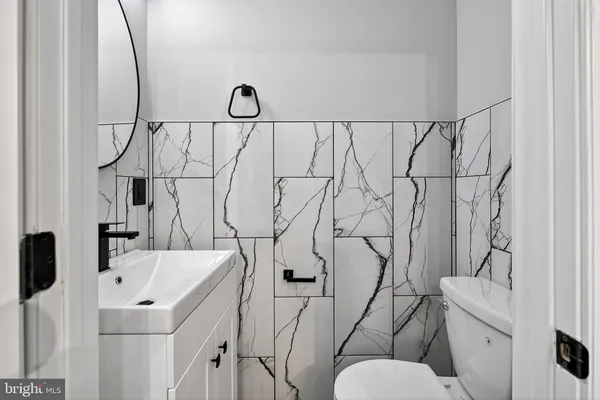 a bathroom with a sink and mirror with toilet
